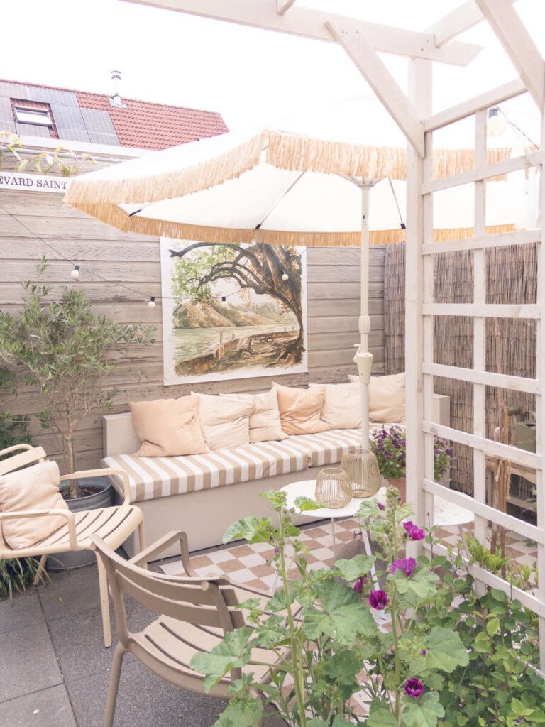 Detail van handgenaaide franjeband aan witte parasol