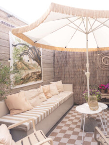Ibiza lounge hoek tuin met witte parasol, kussens en naturel accessoires